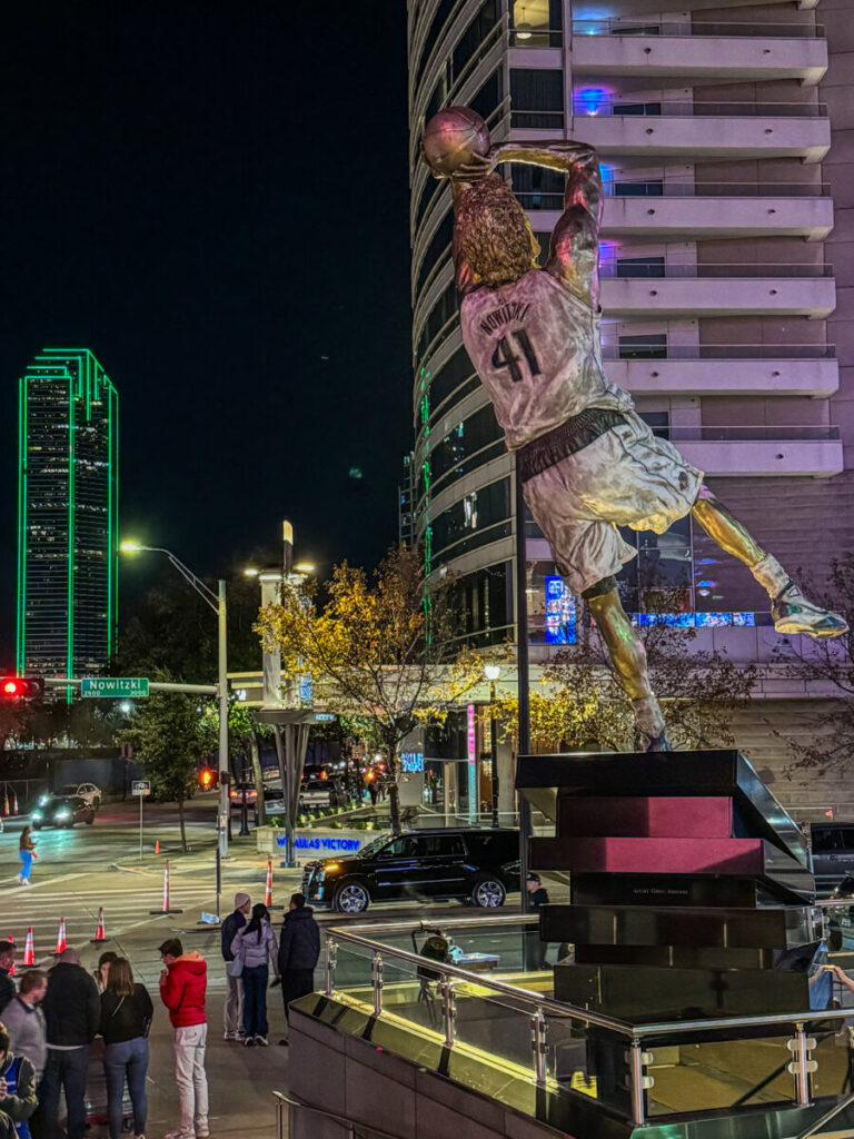 Dieses Bild zeigt die Dirk Nowitzki Statue vor dem Haupteingang des American Airlines Center Dallas